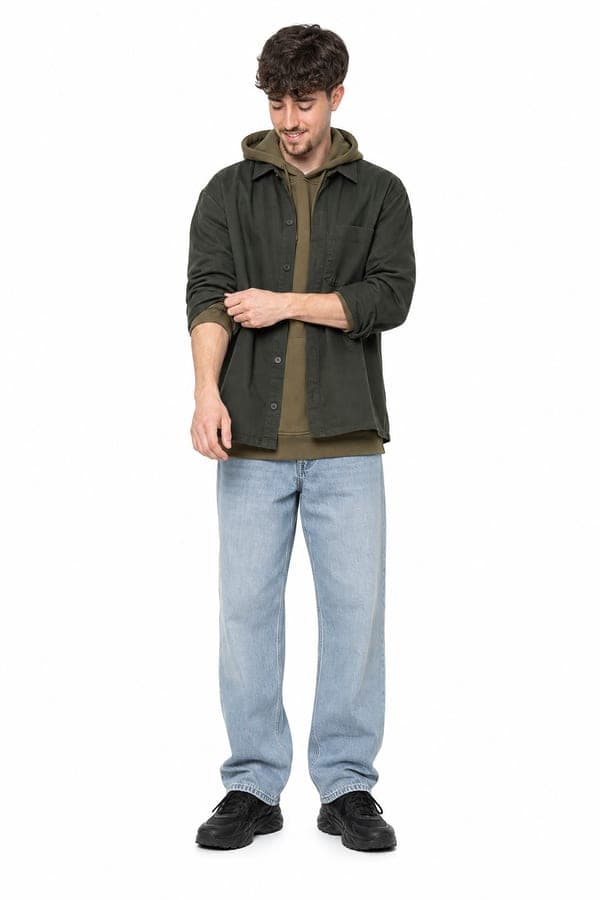 An olive hoodie under a jacket, with light denim jeans, for a street-driven day.